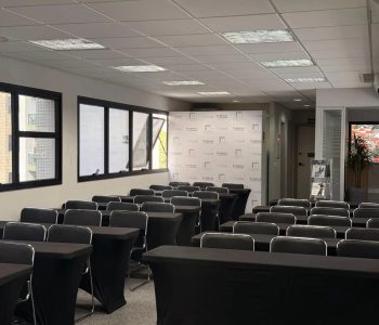 Auditório do terceiro andar da Fismatek com mesas em formato de sala de aula para treinamentos